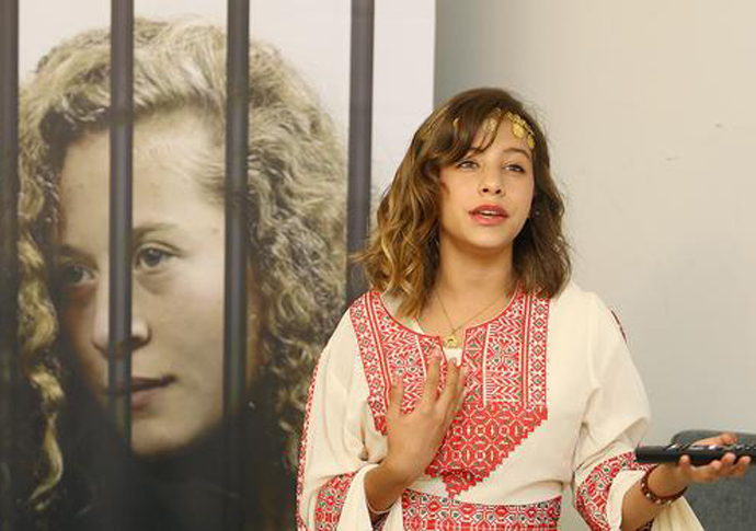 Jana Tamimi South Africa tour standing by a poster photo of her cousin Ahed Tamimi