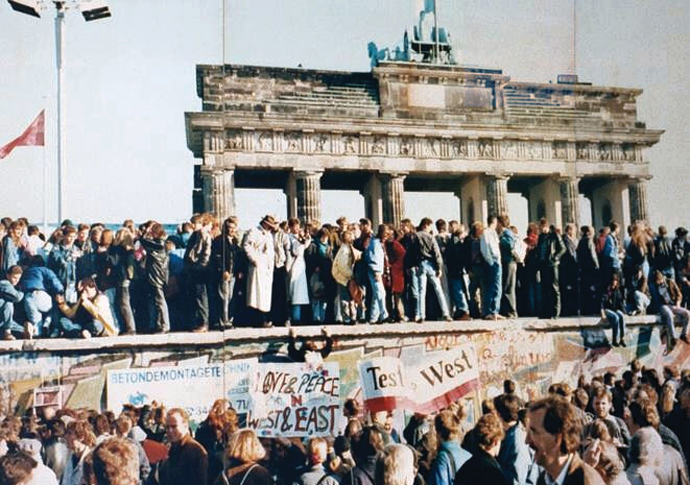 Loss and profit West and East Germans at Berlin Wall in front of the Brandenburg Gate in 1989 shortly before its fall_photo CC BY-SA 3.0 Deed